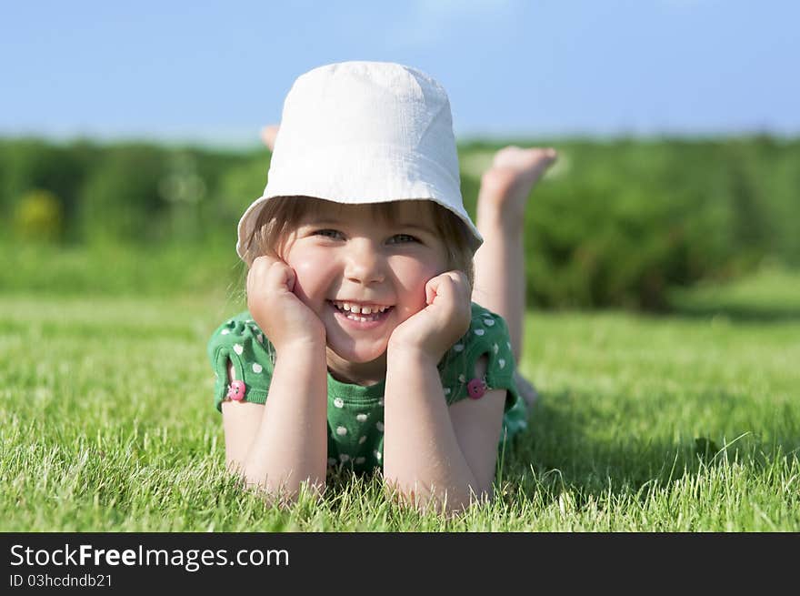 Little adorable girl lying on green grass in park. Little adorable girl lying on green grass in park