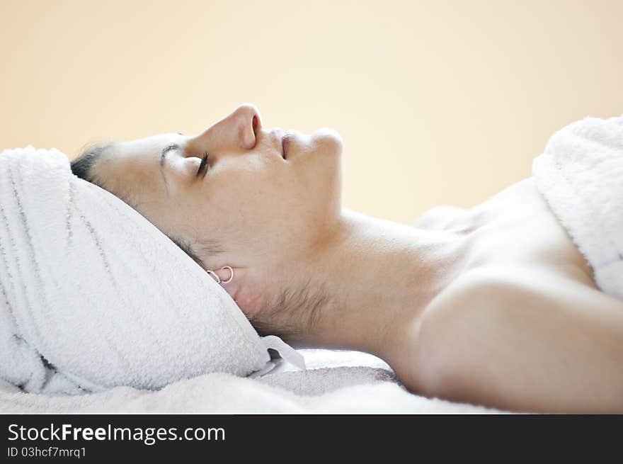 An attractive Caucasian woman lying down on a massage bed. An attractive Caucasian woman lying down on a massage bed