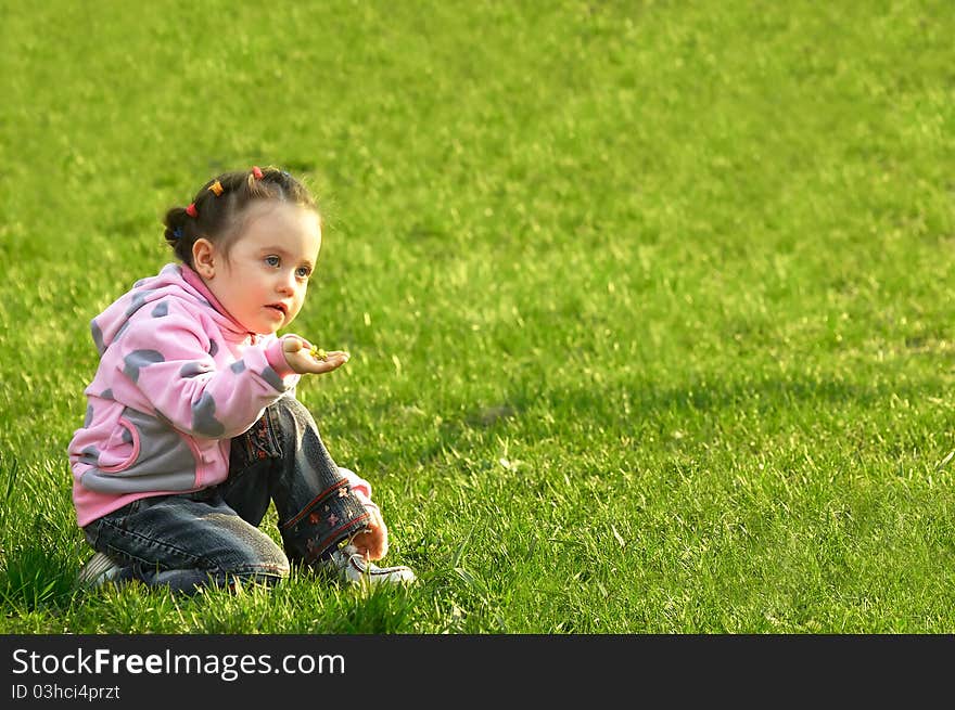 The child a smelling flower in a green grass