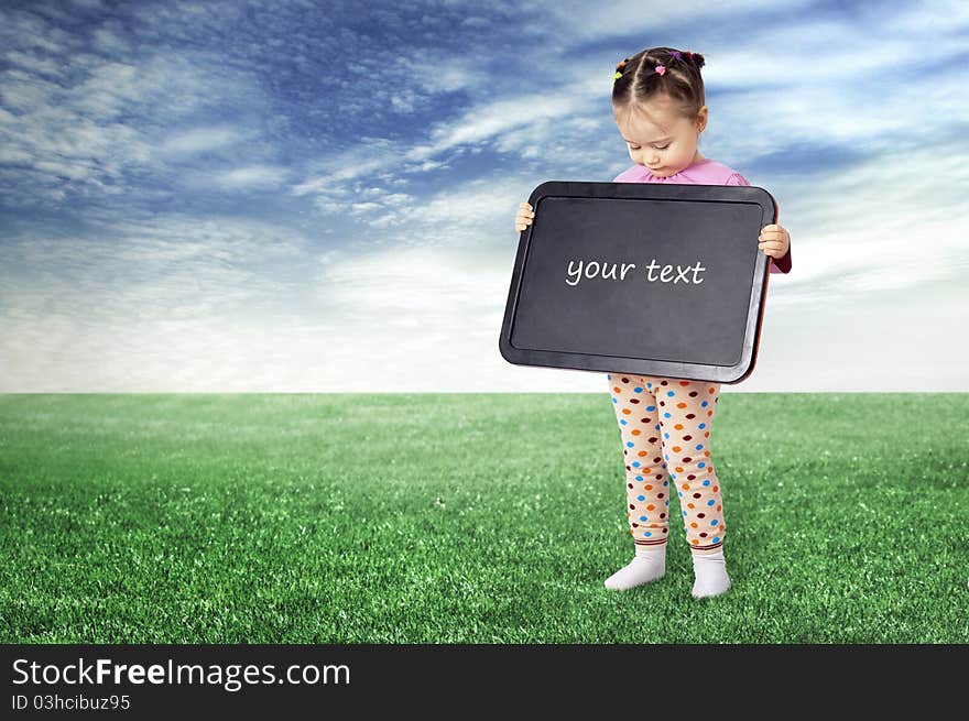 The girl with a board for drawing on a meadow