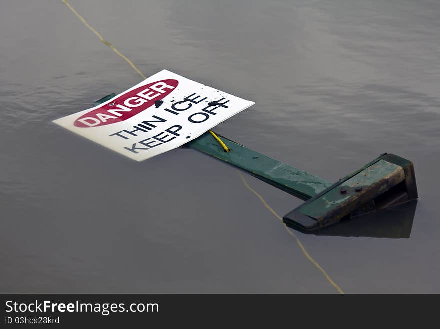 Thin ice sign in a melted pond. Thin ice sign in a melted pond