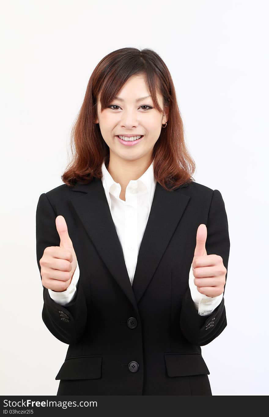 Smiling young japanese business woman showing thumbs up gesture. Smiling young japanese business woman showing thumbs up gesture