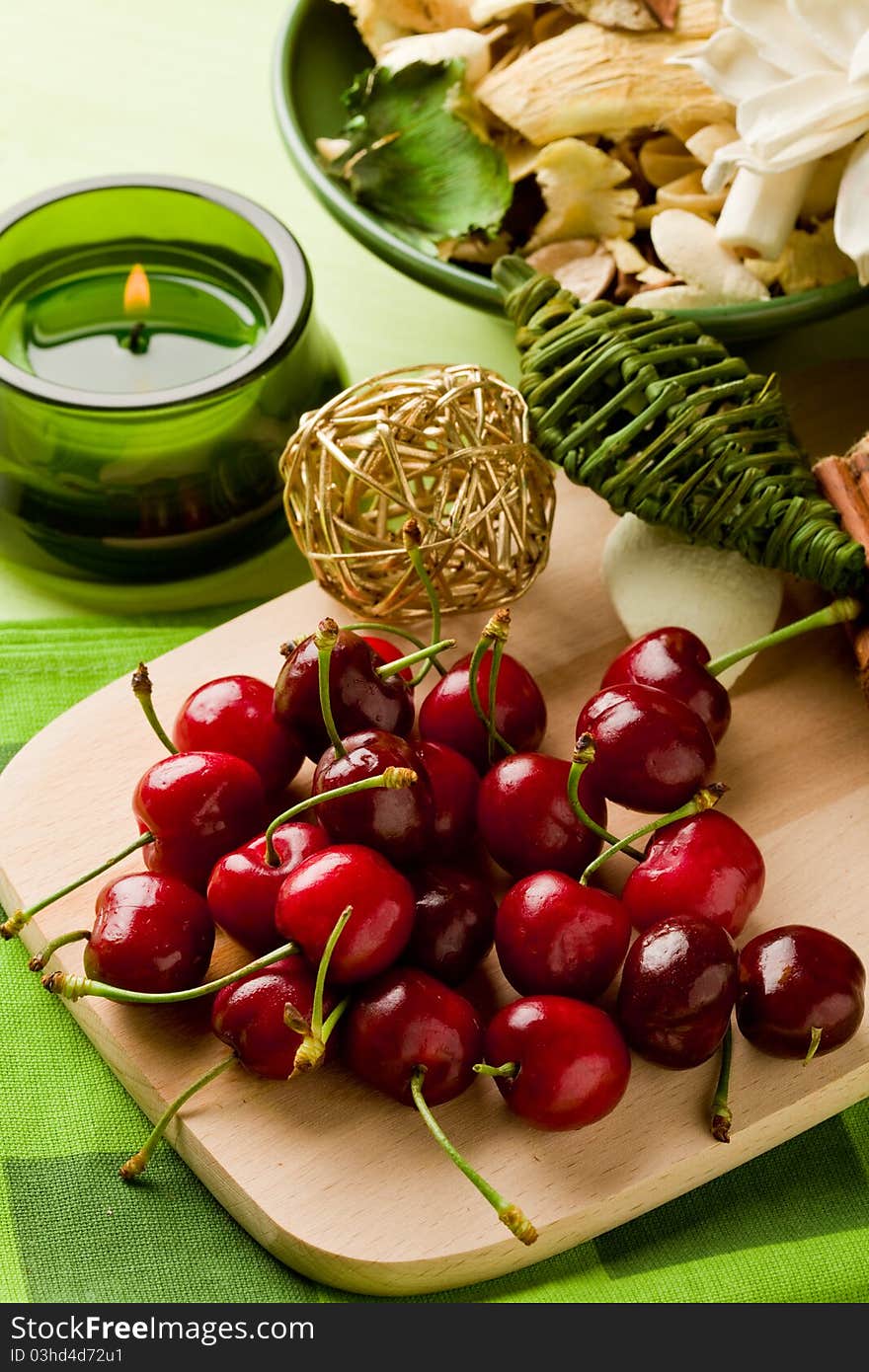 Photo of delicious cherries on cutting board with decoration around. Photo of delicious cherries on cutting board with decoration around