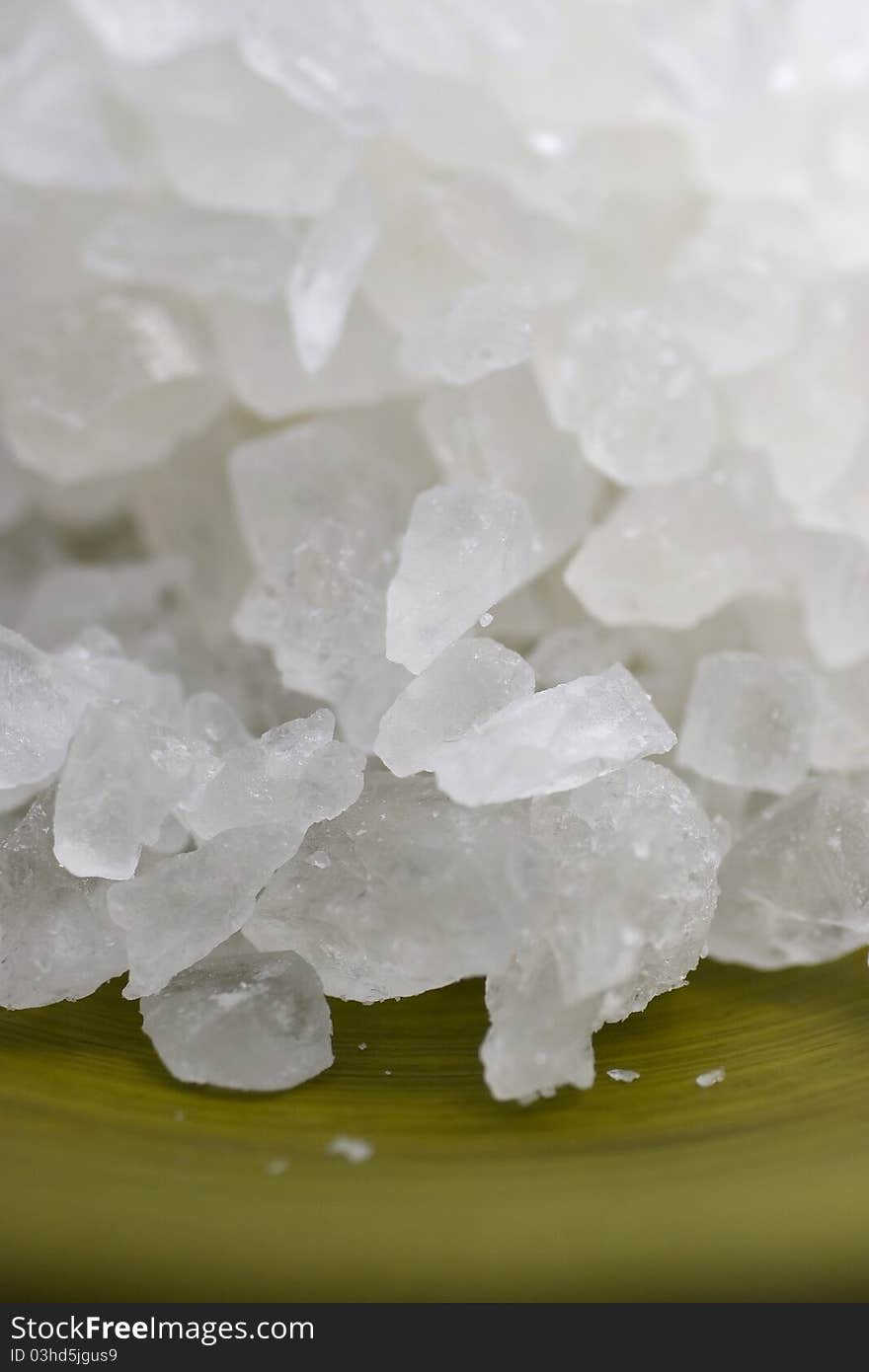 Macro image of crystalized rock salt in a green bowl