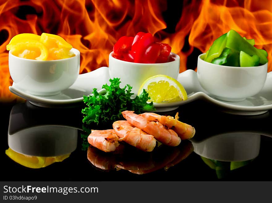 Photo of king prawns on black glass table with flames. Photo of king prawns on black glass table with flames