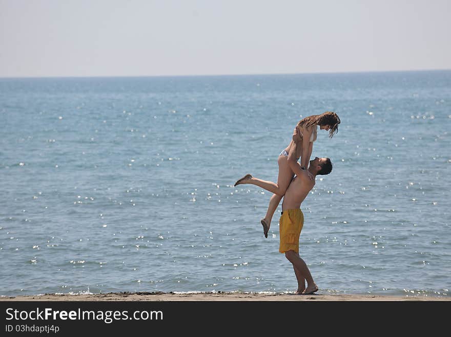 Happy young couple have fun and romantic moments on beach at summer season and representing happynes and travel concept. Happy young couple have fun and romantic moments on beach at summer season and representing happynes and travel concept