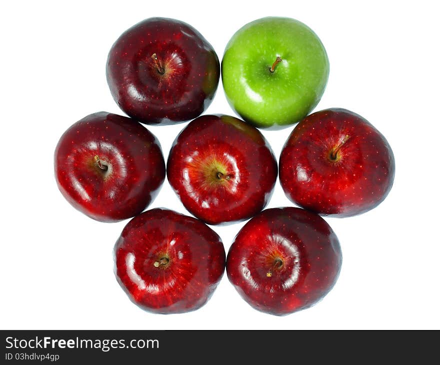 A green apple put among red apples isolated on white background. A green apple put among red apples isolated on white background.