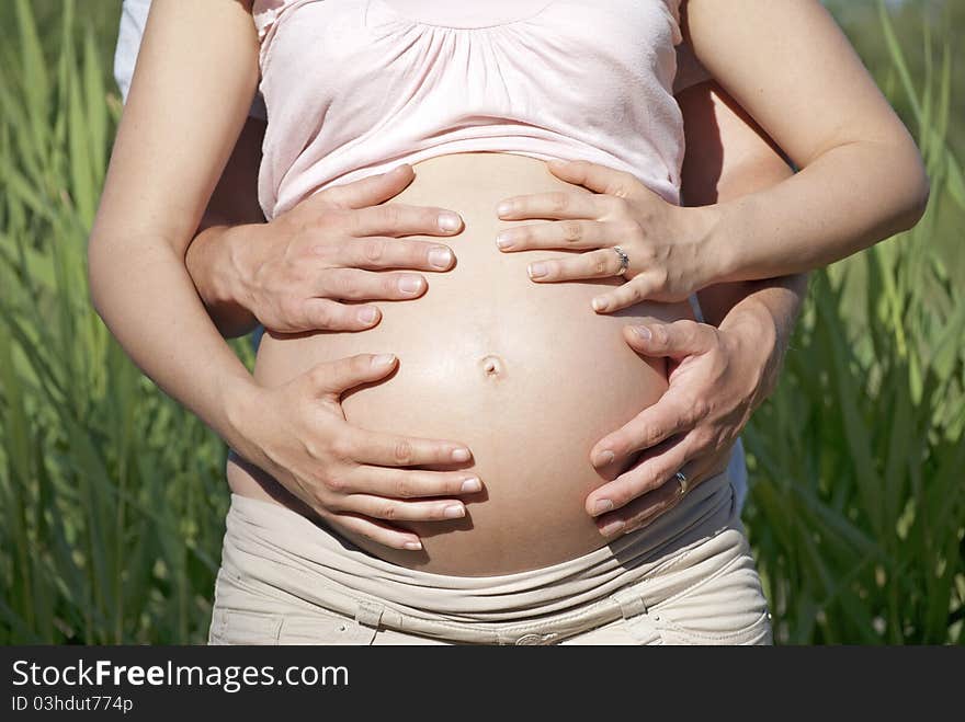 Hands covering pregnant belly - bonding. Hands covering pregnant belly - bonding