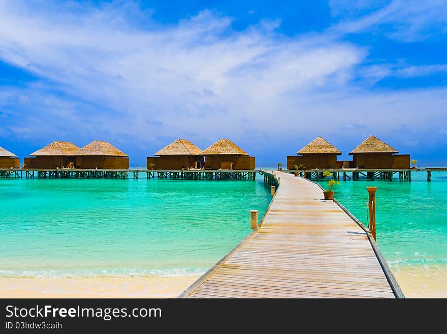 Water bungalows at a tropical island - travel background. Water bungalows at a tropical island - travel background