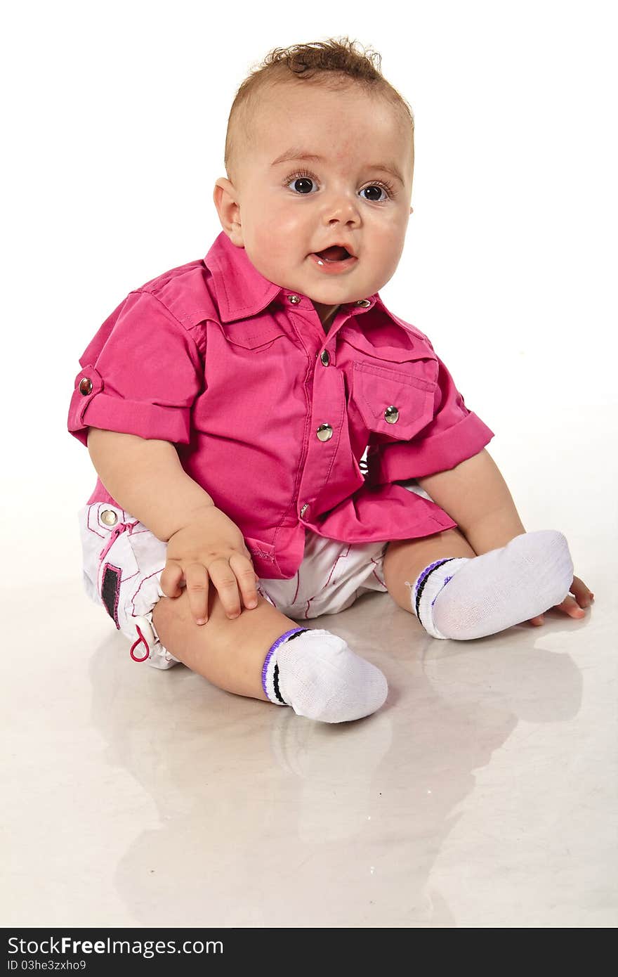 Little Boy In Shorts And A Pink Shirt Sitting