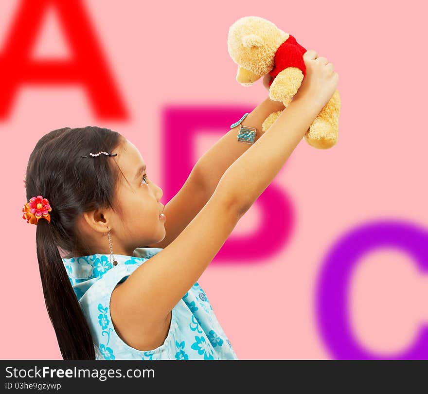 Girl Holding Her Teddy Bear Up In The Air