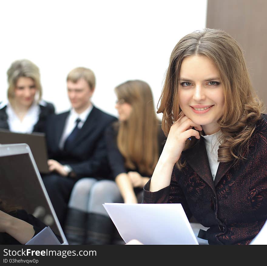 Portrait of a smart young businesswoman with people at the back