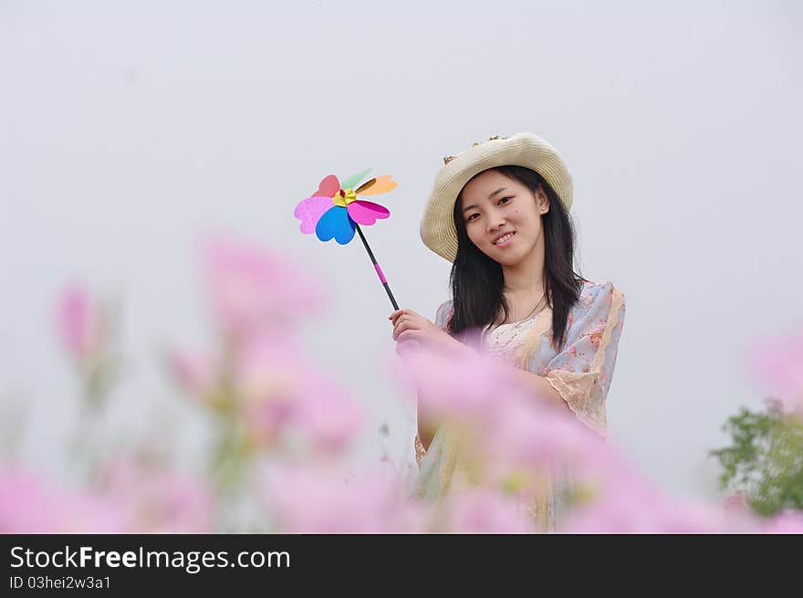 A girl in garden with pinwheel in hand. A girl in garden with pinwheel in hand