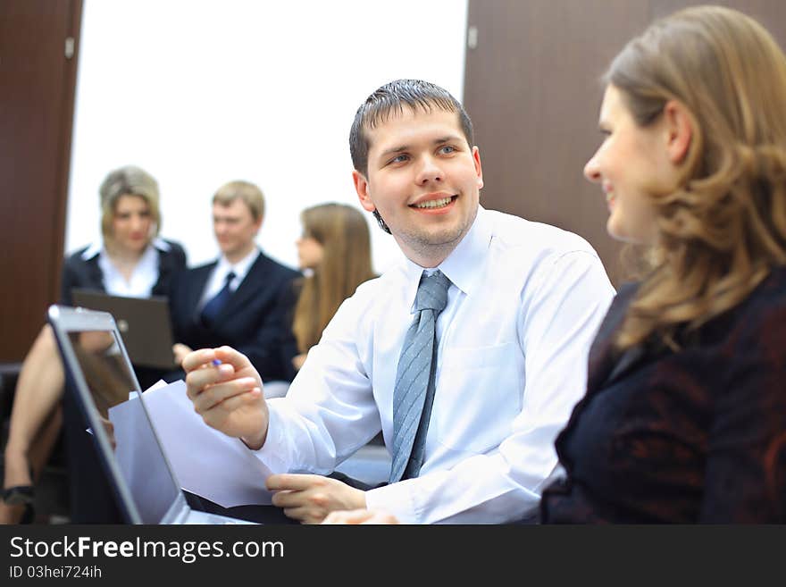 Colleagues sitting at table and discussing during business meeting