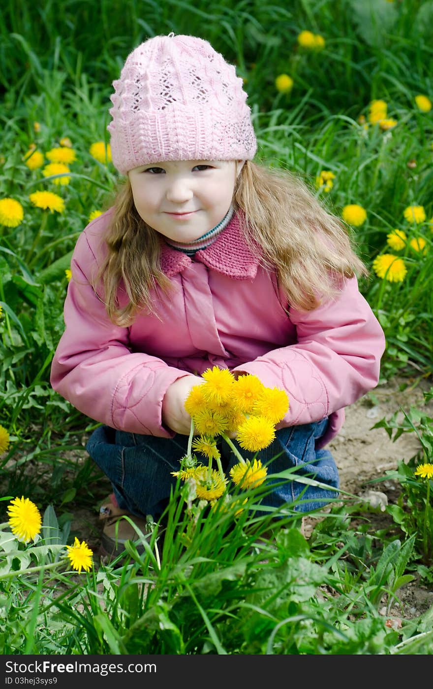 Portrait of the little girl with dandelions outdoor