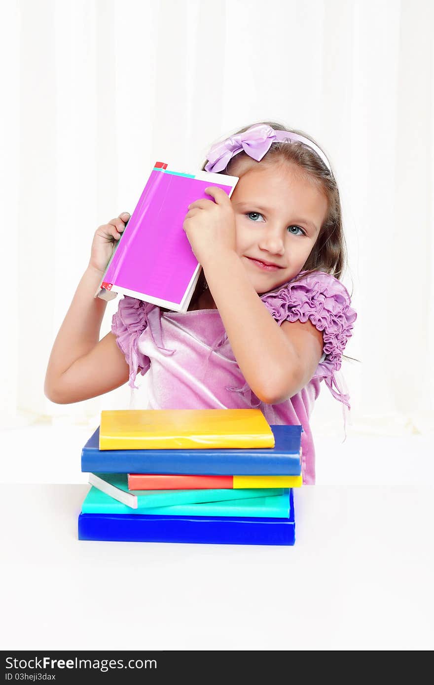 Happy little girl playing with books