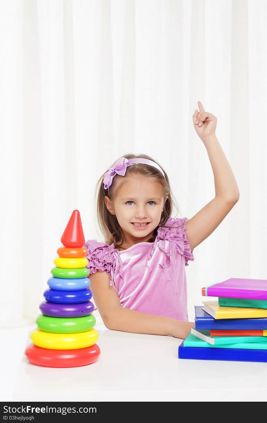 Happy little girl playing with books