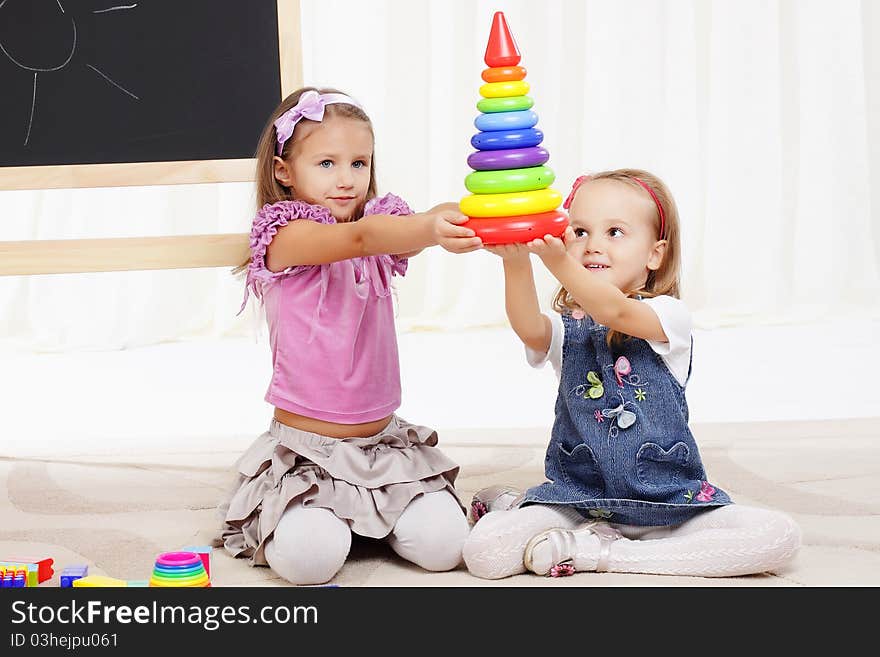 Two little girls play with toys