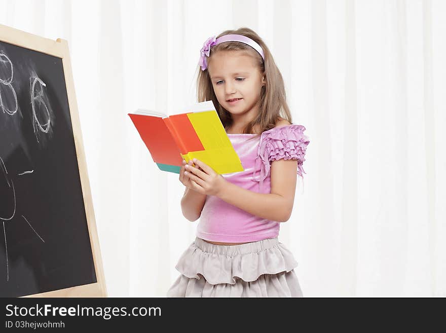 Happy little girl plays the role of a teacher. Happy little girl plays the role of a teacher