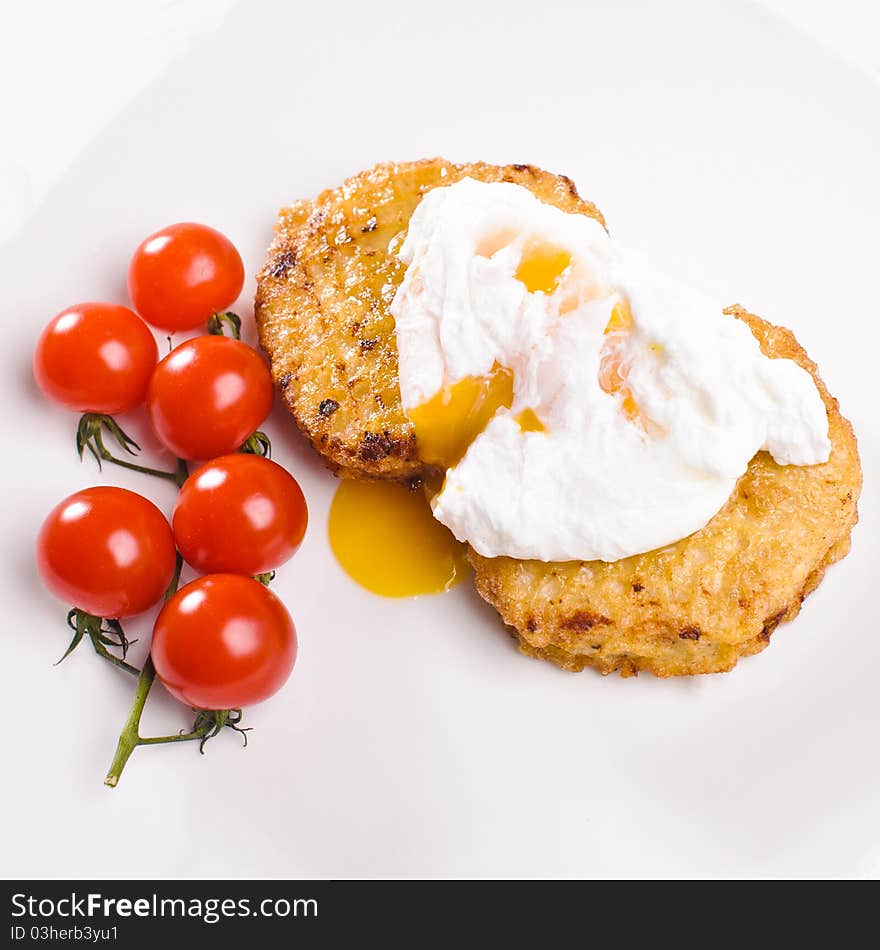 Two cutlets with branch of small tomatos and egg on white plate