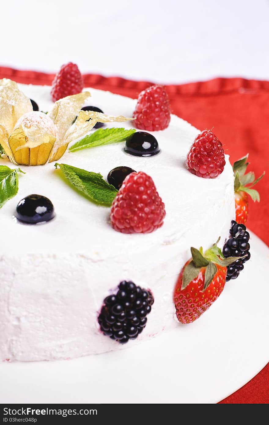 Piece of cake on plate with berries and fruits