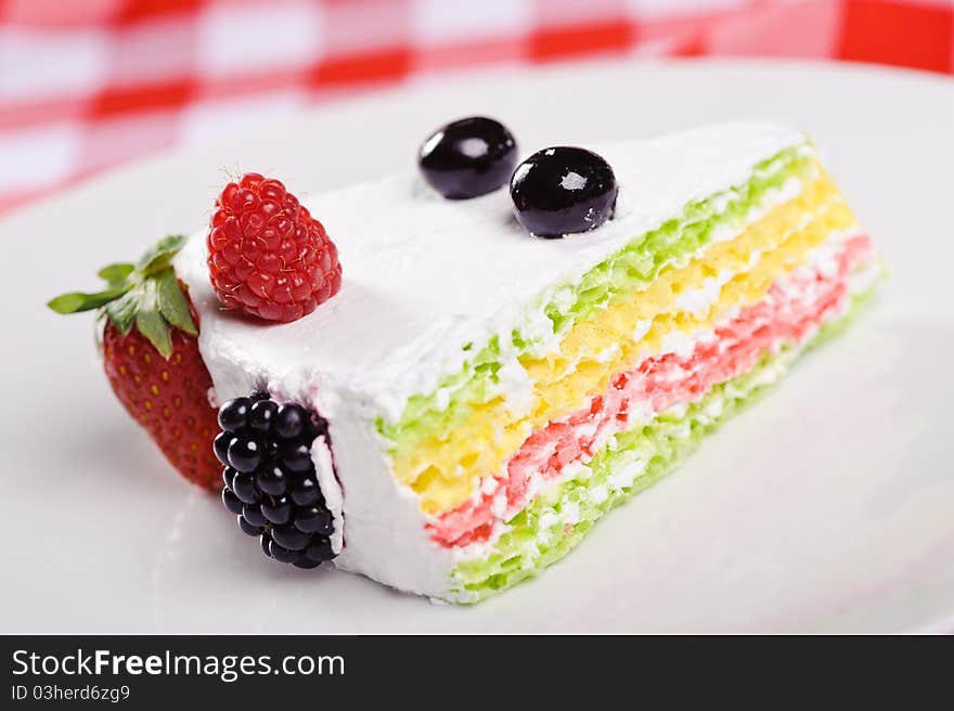 Piece of cake on plate with berries and fruits