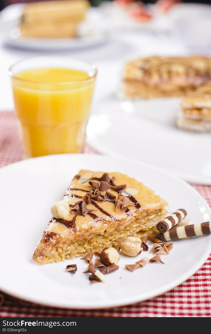 Piece of cake with chokolate and juice on white plate