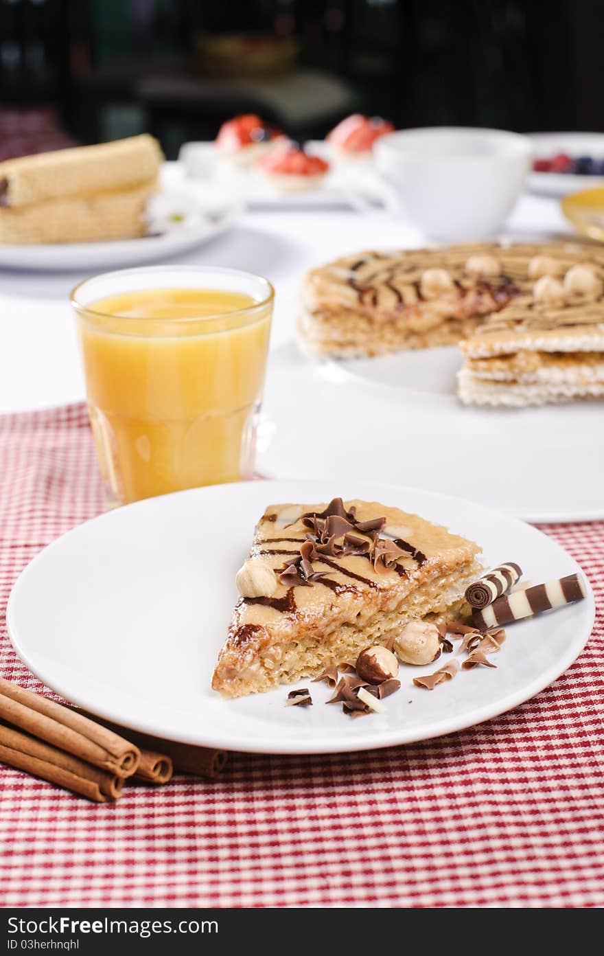 Piece of cake with chokolate and juice on white plate