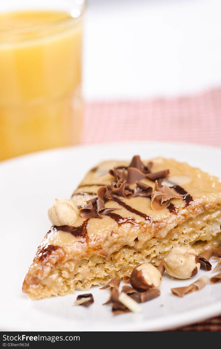 Piece of cake with chokolate and juice on white plate