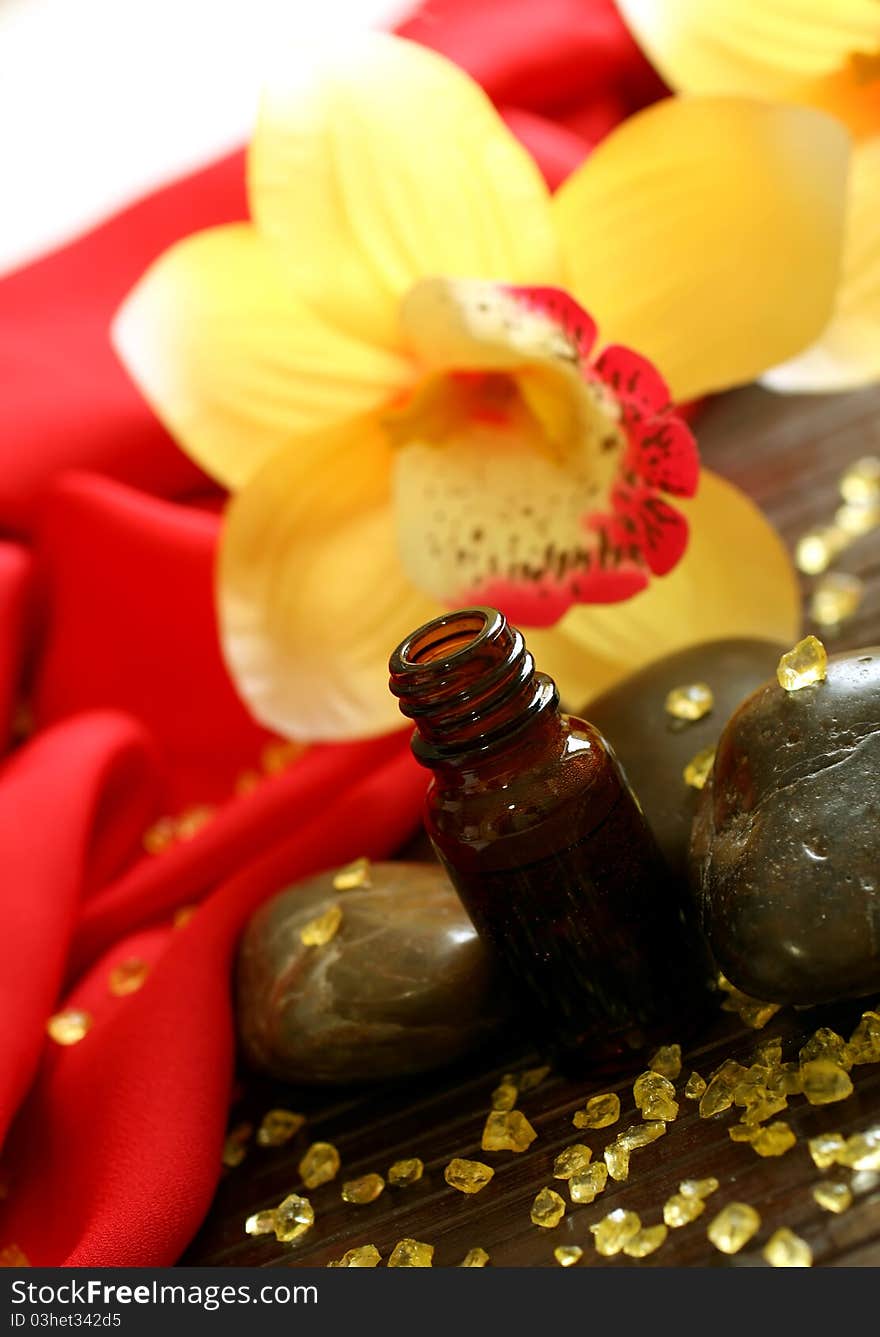 Bottle of essence oil, stones, bath salt and yellow flowers. Bottle of essence oil, stones, bath salt and yellow flowers