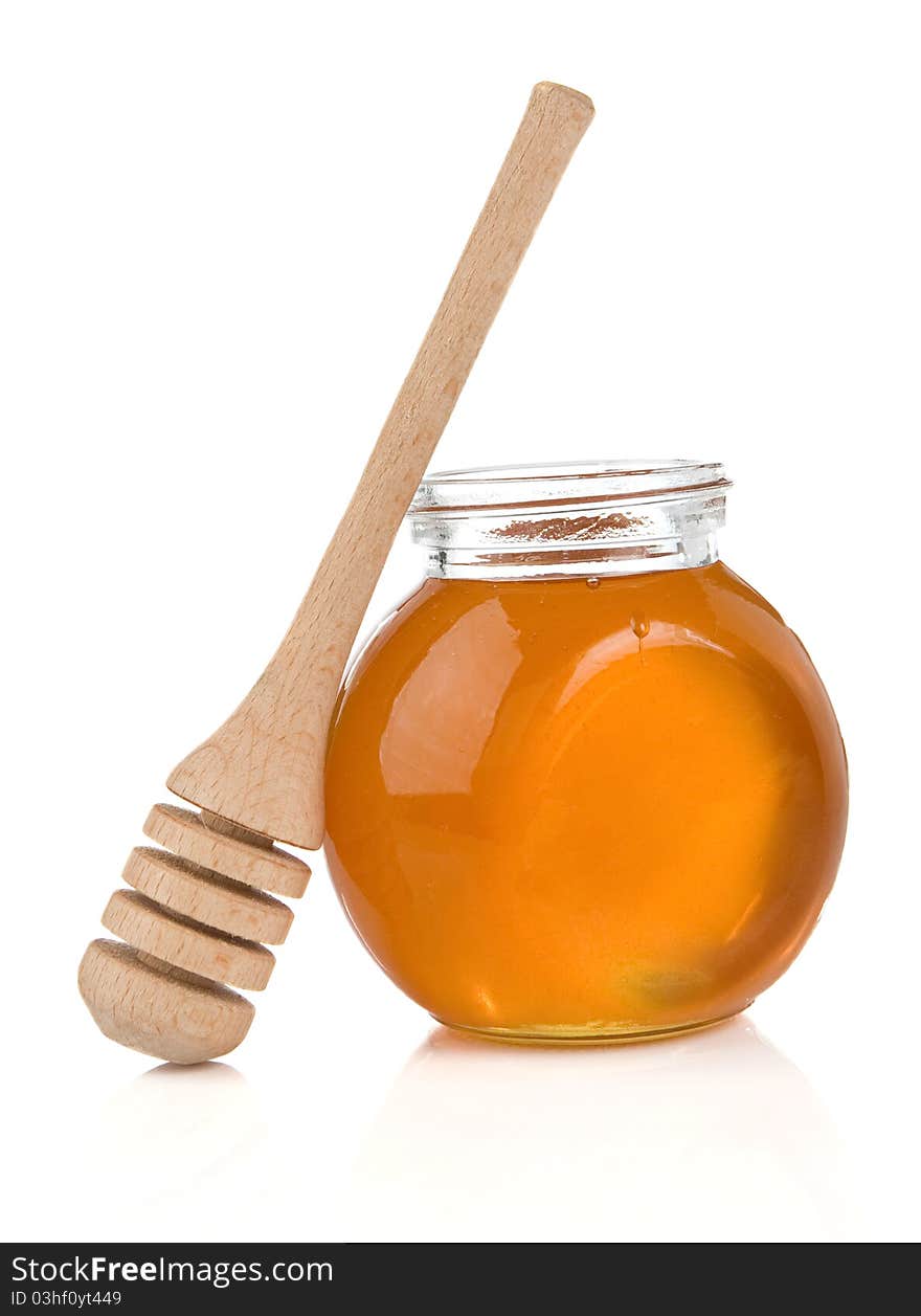 Glass pot full of honey and stick isolated on white background. Glass pot full of honey and stick isolated on white background