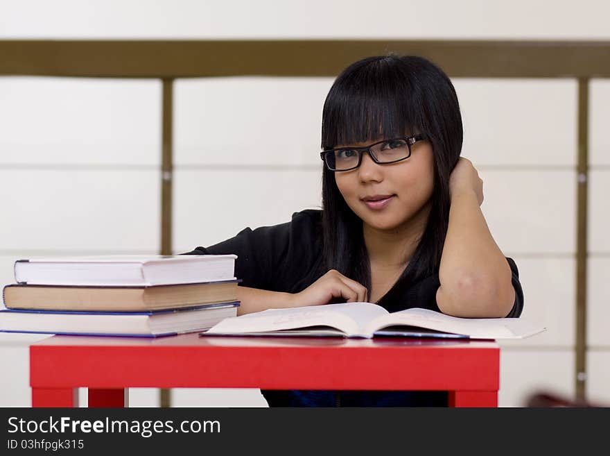 Young girl reading books in library