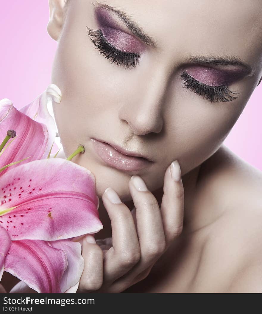 Portrait of a blond beauty with flowers on the pink background. Portrait of a blond beauty with flowers on the pink background
