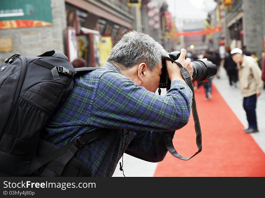 A photographer is shooting the streets of ancient China. A photographer is shooting the streets of ancient China.