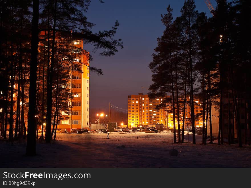 Bright illuminated city houses in forest. Bright illuminated city houses in forest