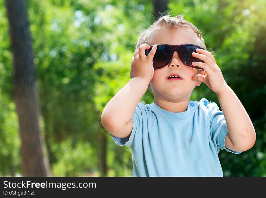 Cute 2 years old boy Sunglasses outdoors at sunny summer day. Cute 2 years old boy Sunglasses outdoors at sunny summer day