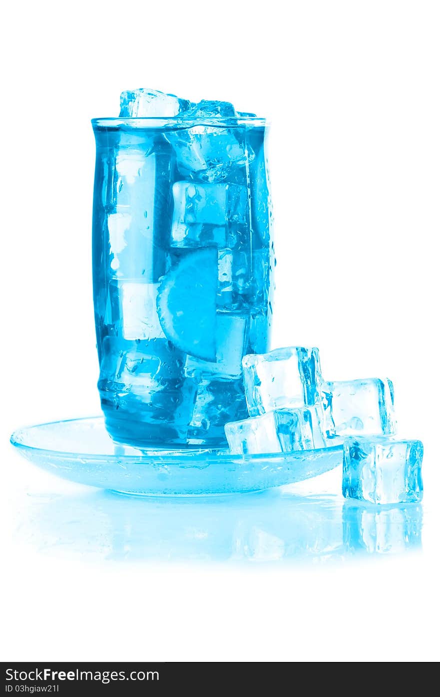 Glass of iced mineral water with ice cubes and lime, covered with water drops on white wet surface with reflection. Blue colored image