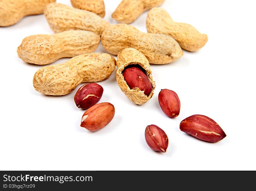 Groundnuts in their skins on white