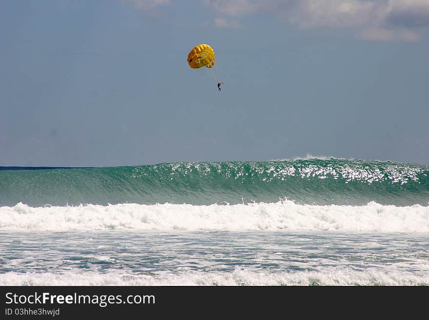 Parasailing over crashing waves in the Indian Ocean