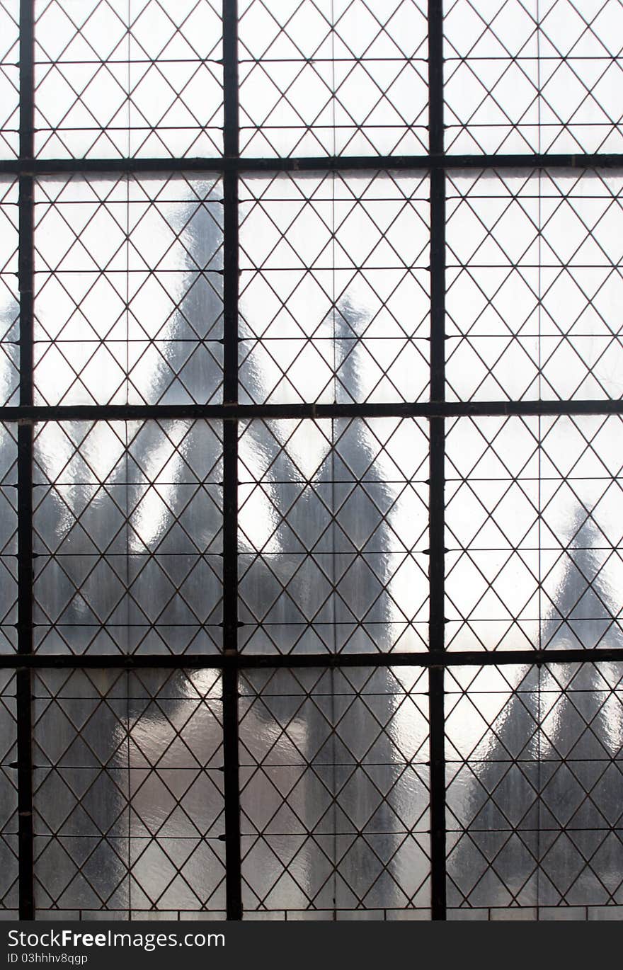 View from iron net through window to an old сatholic palace. View from iron net through window to an old сatholic palace