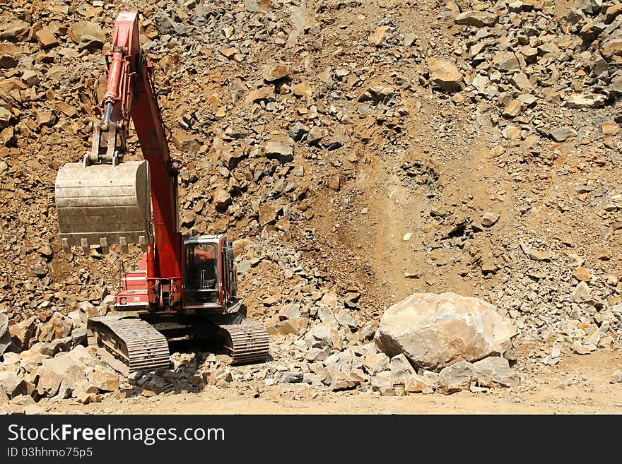 Stone quarry excavator at work and squashed rocks