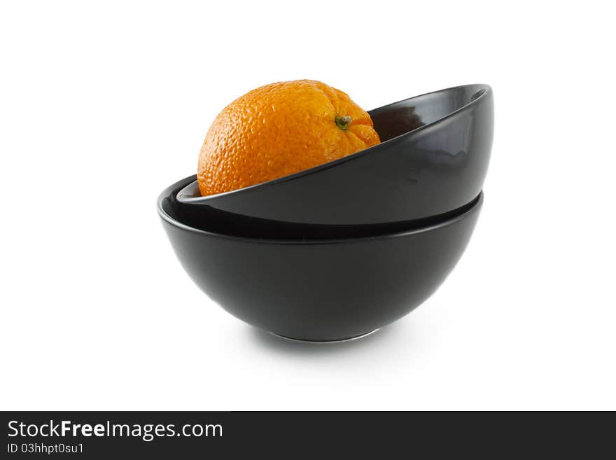 Orange and two ceramic black plates over white background