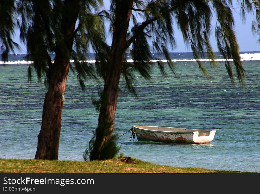 Beach scene with tranquil sea and deserted boat in Mauritius. Beach scene with tranquil sea and deserted boat in Mauritius.