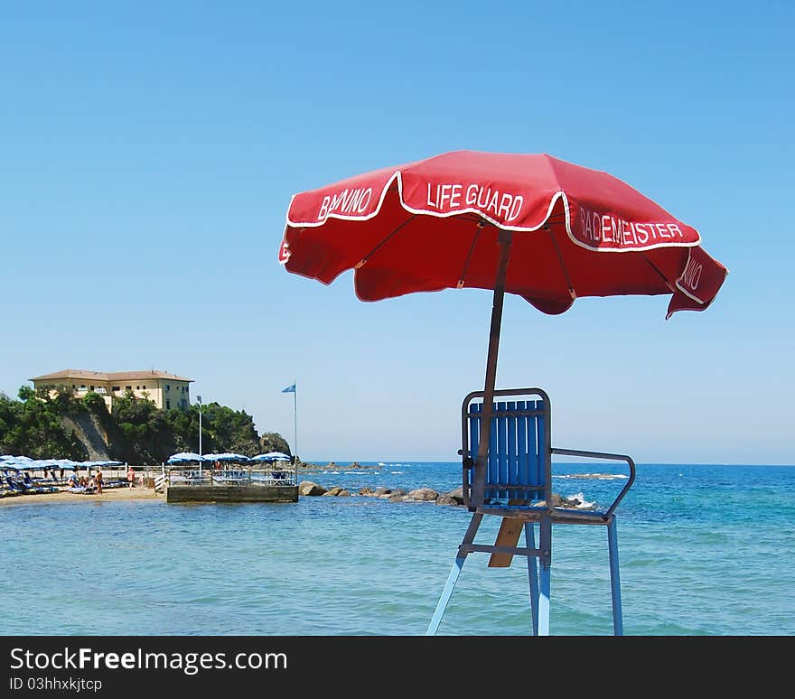 Red life guard umbrella, beach and sea view
