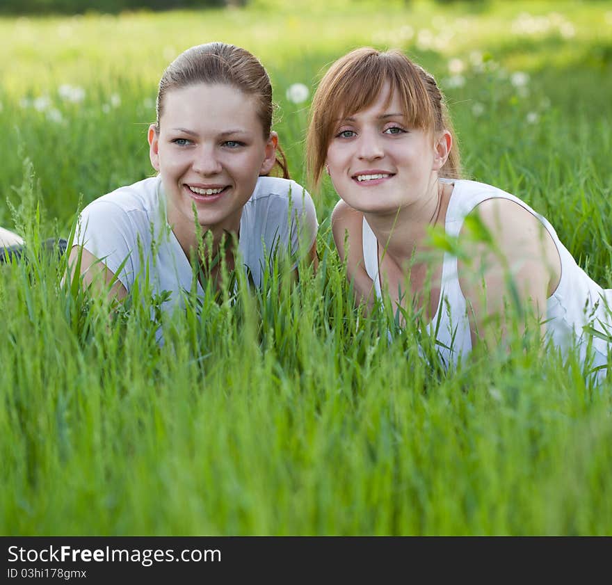 Two girls lying in a grass in the park zone. Two girls lying in a grass in the park zone