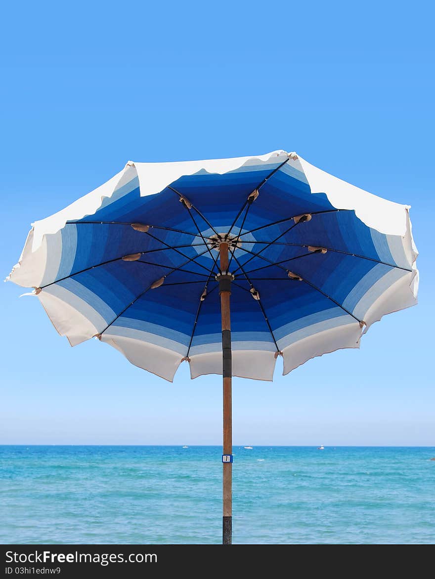 Blue and white umbrella in the beach. Blue and white umbrella in the beach