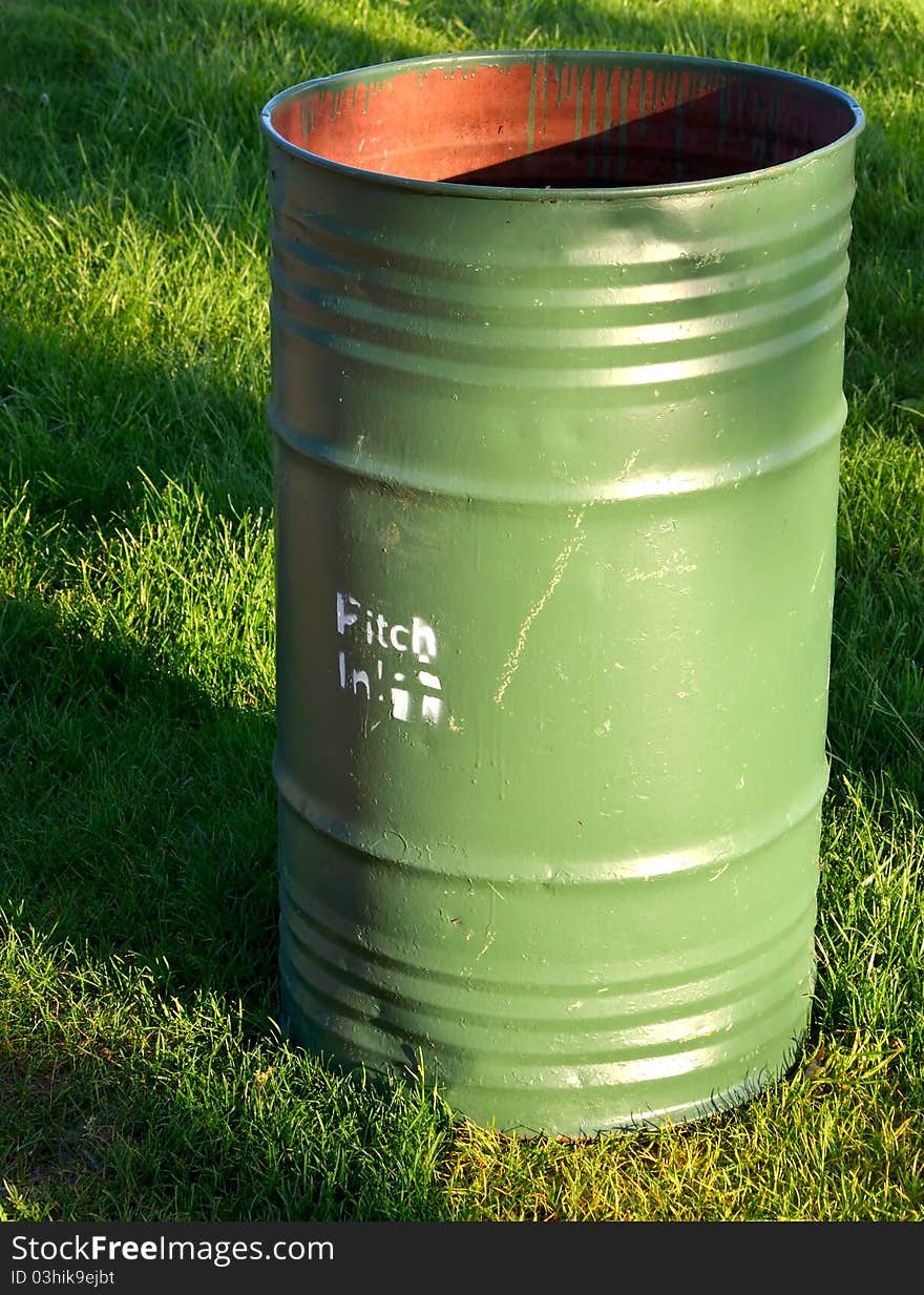 Green trashcan in park on green grass. Green trashcan in park on green grass