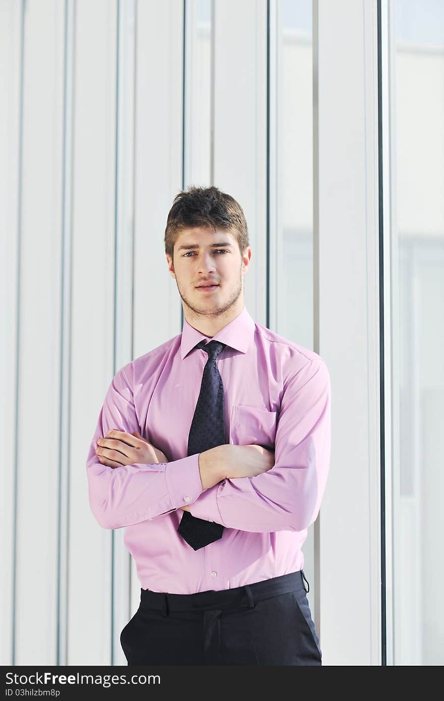 Young business man talk by cellphone over bright window in big hall