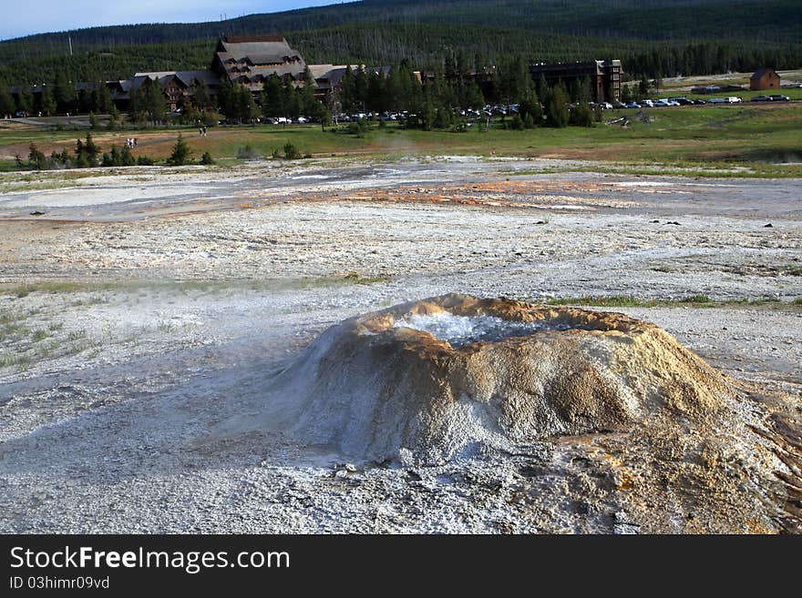 Bubbling Geyser in Yellowstone National Park,Old Faithful Inn with forests as background.