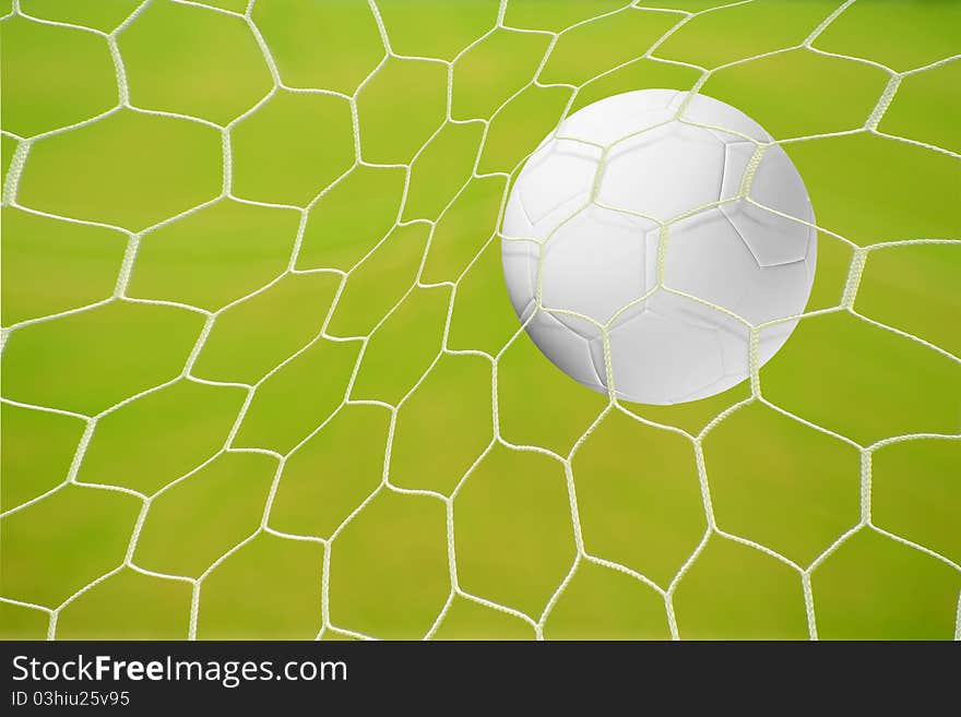 A goal in a soccer match: traditional black and white football hitting the big net in front of blue sky background. A goal in a soccer match: traditional black and white football hitting the big net in front of blue sky background